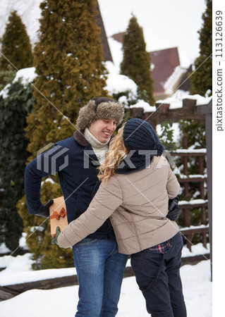 Man is hides box behind his back and going to give his woman a present on Valentine's Day, Christmas or New Year. Boyfriend and girlfriend dating romance. Husband gives gift to wife on her birthday. 113126639