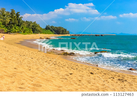 View of the shore of the South China Sea with a sandy beach and large rocks. Sanya, China. 113127463