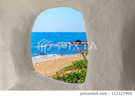 Beach at World's End Park, Sanya, China. View of the beautiful beach and sea from the white bungalow Beach at World's End Park, Sanya, China. View of the beautiful beach and sea from the white bungalow 113127469