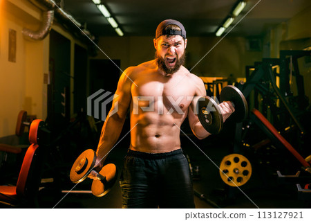 man in gym training with dumbbells 113127921