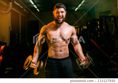 man in gym training with dumbbells 113127930