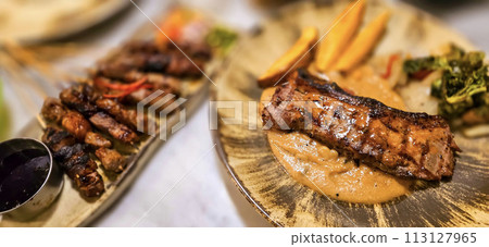 New york strip loin beef steak meat with mushroom sauce and potato wedges and salad plated on beautiful plate New york strip loin beef steak meat with mushroom sauce and potato wedges and salad plated on beautiful plate 113127965