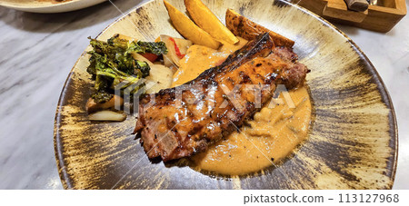 New york strip loin beef steak meat with mushroom sauce and potato wedges and salad plated on beautiful plate 113127968