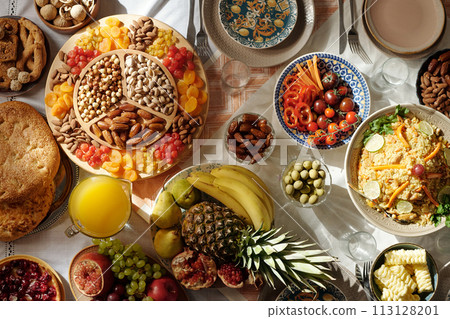 Top-down flat lay no people shot of abundant festive table served with colorful delicious food for Eid Al-Fitr celebration Top-down flat lay no people shot of abundant festive table served with colorful delicious food for Eid Al-Fitr celebration 113128201