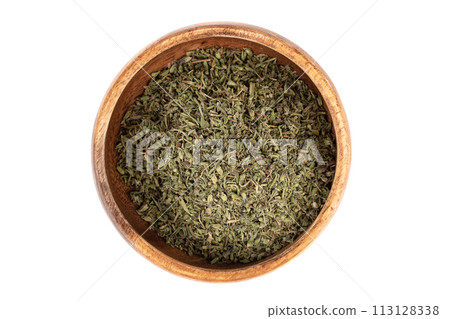 Top view of a wooden bowl with dried thyme leaves on a white background. 113128338