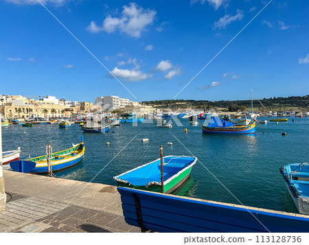 Fishing boats in the harbor of Marsaxlokk, Malta in a beautiful sunny day Fishing boats in the harbor of Marsaxlokk, Malta in a beautiful sunny day 113128736