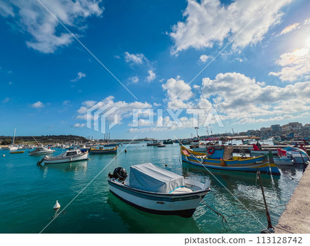Fishing boats in the harbor of Marsaxlokk, Malta in a beautiful sunny day Fishing boats in the harbor of Marsaxlokk, Malta in a beautiful sunny day 113128742