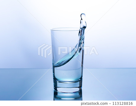 splash of water in a glass on a light background 113128816