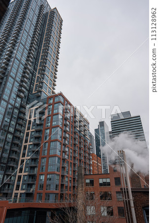 chimney pipe with steam at New York or Toronto, smoke stack on big city with skyscrapers urban background chimney pipe with steam at New York or Toronto, smoke stack on big city with skyscrapers urban background 113128962