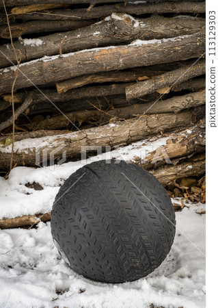 heavy, 50 lb, slam ball filled with sand in a snowy backyard, exercise and functional fitness concept 113129303