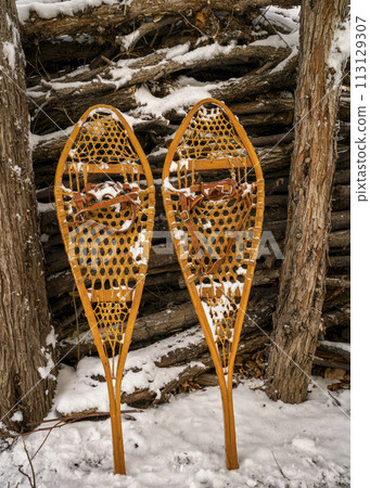 Classic wooden snowshoes (Huron) in a backyard covered by snow Classic wooden snowshoes (Huron) in a backyard covered by snow 113129307