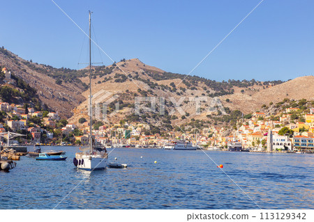 Multi-colored facades of houses in the Greek village Symi on a sunny day 113129342