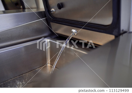 Industrial dishwasher in restaurant kitchen washing dishes 113129499