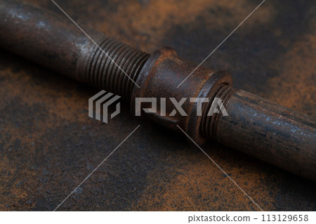 Rusty plumb tube on rusty metal wall 113129658