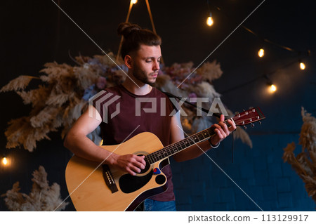 Male musician playing acoustic guitar. Guitarist 113129917