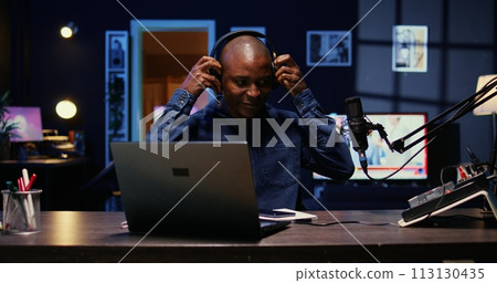 Portrait of african american man starting live broadcast on streaming platform, greeting viewers. Cheerful internet star arriving in studio, ready to create content for his audience 113130435
