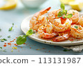 Grilled shrimp on a white plate with fresh basil and lemon on blue background 113131987