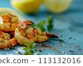 Juicy grilled shrimp seasoned with spices and garnished with parsley, served with lemon on a blue plate 113132016