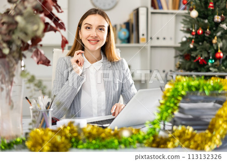 Successful business woman using laptop at workplace during christmas 113132326