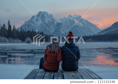 A couple is sitting on a dock overlooking a lake A couple is sitting on a dock overlooking a lake 113132546