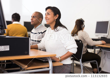 Young adult woman studying in computer class Young adult woman studying in computer class 113132693