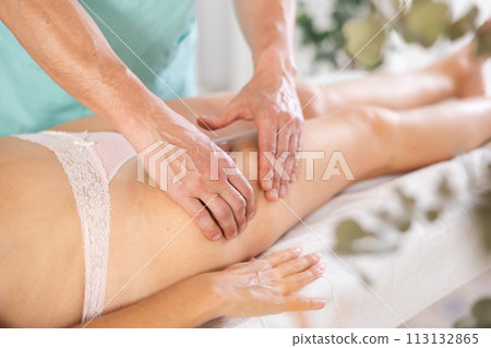 Female legs lie on massage table during anti-cellulite complex of procedures Female legs lie on massage table during anti-cellulite complex of procedures 113132865
