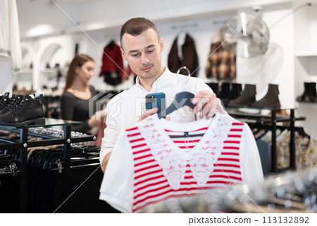 Young man makes video call and chooses blouse 113132892