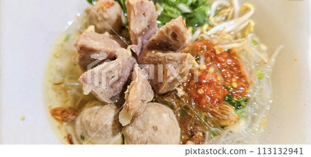 Bakso, indonesian meatball style served with beef broth soup and noodle springkled with fried onion and spring onion coupled with chili sauce on the top 113132941