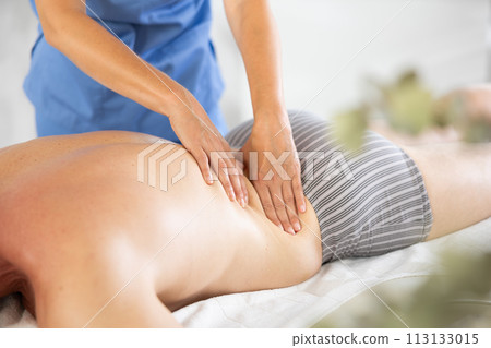massage therapist doing a back massage 113133015