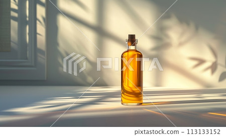 A bottle of liquor is sitting on a table in the sunlight 113133152