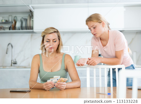 Mother gives teenage daughter bills small amount of pocket money. 113133228