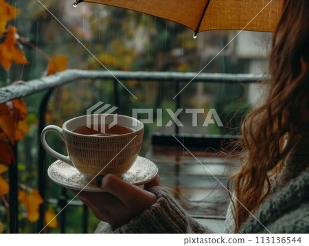 A woman savors a warm cup of tea, enjoying the tranquility of a rainy day through a window A woman savors a warm cup of tea, enjoying the tranquility of a rainy day through a window 113136544