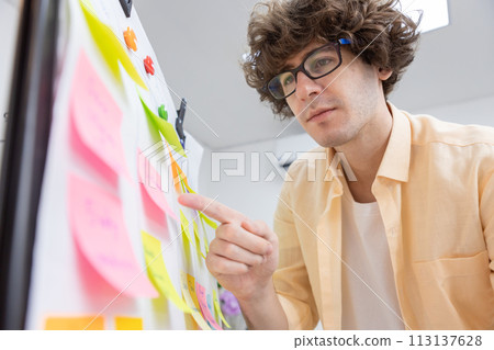 businessman working pointing post it sticky notes information on glass board at office. planning and strategy meeting presentation project. businessman working pointing post it sticky notes information on glass board at office. planning and strategy meeting presentation project. 113137628