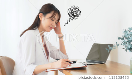 A depressed middle-aged woman in a white coat 113138453