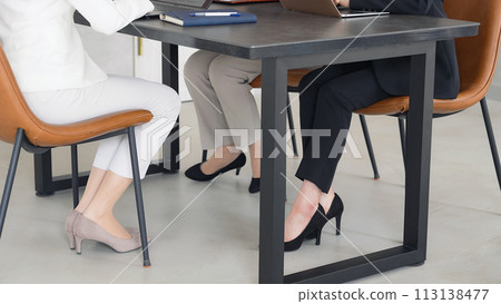 Feet of group of businesswomen meeting in office 113138477