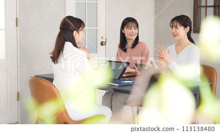 Group of women in casual wear having a conversation in the office 113138480