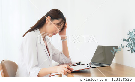 A depressed middle-aged woman in a white coat A depressed middle-aged woman in a white coat 113138529