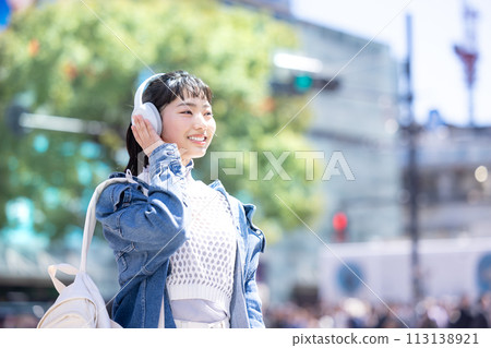 Street Snap Young woman listening to music with headphones 113138921
