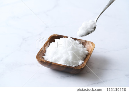 Caster sugar on a wooden plate Caster sugar on a wooden plate 113139358