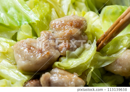 A cooking scene of frying chicken and cabbage in a frying pan. A cooking scene of frying chicken and cabbage in a frying pan. 113139638