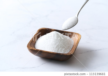 Granulated sugar on a wooden plate Granulated sugar on a wooden plate 113139681