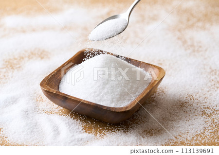 Granulated sugar on a wooden plate Granulated sugar on a wooden plate 113139691