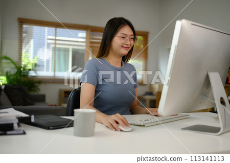 Delighted young woman in casual clothes remote working from home 113141113