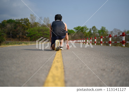 Low angle view of sportsman in low starting position preparing for run 113141127