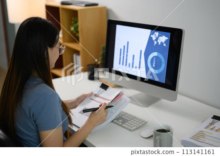 Young female entrepreneur working at home with graphs, charts on computer screen Young female entrepreneur working at home with graphs, charts on computer screen 113141161