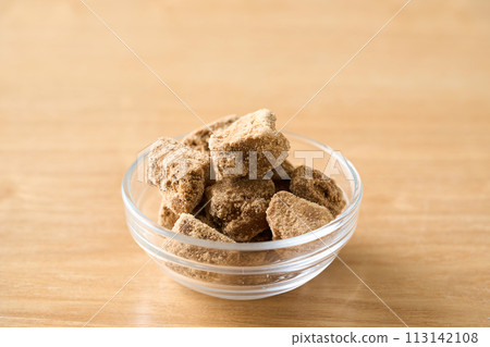 Brown sugar served in a glass tableware Brown sugar served in a glass tableware 113142108