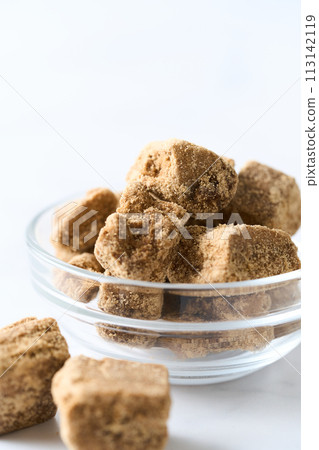 Brown sugar served in a glass tableware 113142119