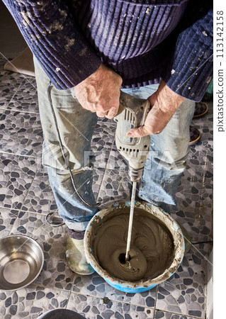 Attachment of hand mixer paddle for power drill for mixing cement mortar in a bucket. Attachment of hand mixer paddle for power drill for mixing cement mortar in a bucket. 113142158
