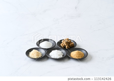 小盤子裡有各種類型的糖：砂糖、紅糖、白糖、甜菜糖和紅糖。 113142426