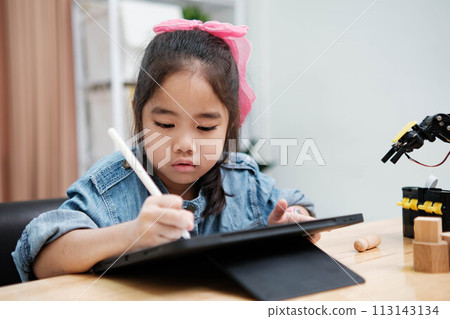 A young girl is playing with a remote control a robot 113143134